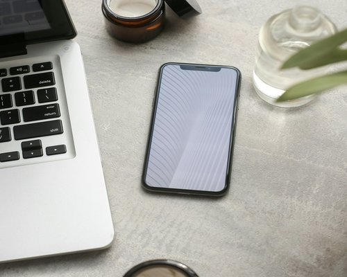 Phone and notebook resting on a desk